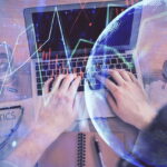 Double exposure of man’s hands typing over laptop keyboard and forex chart hologram drawing. Top view. Financial markets concept.